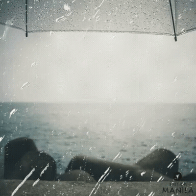 A Manila Photo Of A Person Under An Umbrella With The Ocean In The Background GIF
