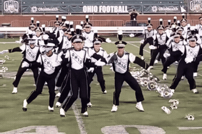 A Marching Band Is Performing On A Field With Ohio Football Banners Behind Them GIF