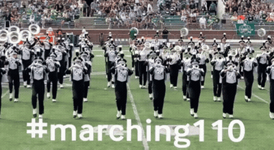 A Marching Band Performs On A Field With The Hashtag # Marching110 Written On The Bottom GIF