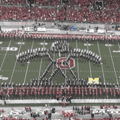 A Marching Band Performs On A Football Field With The Letter O On It GIF