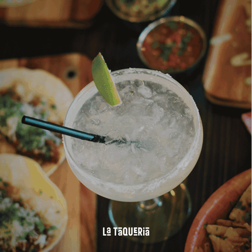 A Margarita With A Straw And A Slice Of Lime Sits On A Table With La Taqueria Written On It GIF