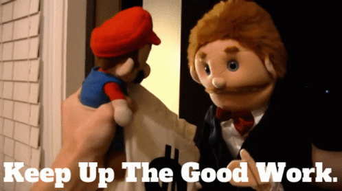 A Mario Puppet Is Being Held By A Person With The Words Keep Up The Good Work Written Below It GIF