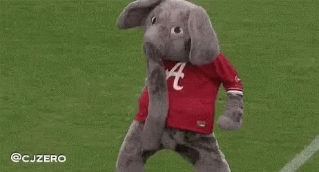 A Mascot Dressed As An Elephant Is Standing On A Field . GIF