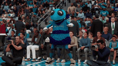 A Mascot For The Charlotte Hornets Stands In Front Of A Crowd Of People GIF