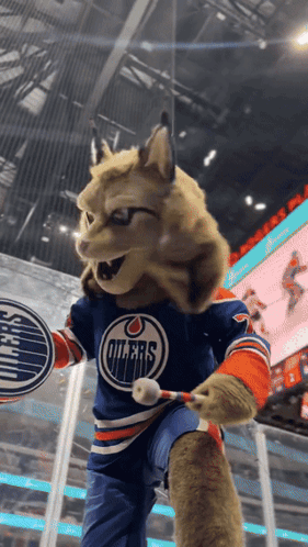 A Mascot For The Edmonton Oilers Is Holding A Hockey Stick GIF
