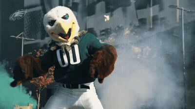 A Mascot For The Philadelphia Eagles Is Standing In Front Of A Building GIF