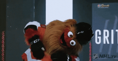 A Mascot For The Philadelphia Flyers Is Dancing In Front Of A Nhl Tv Sign GIF