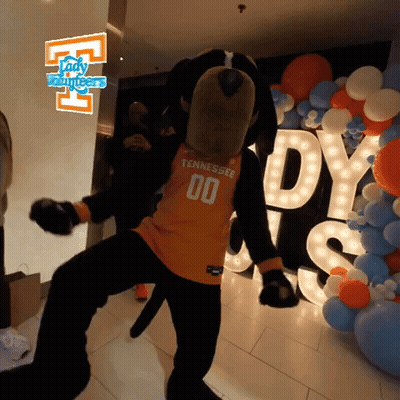 A Mascot From Tennessee Is Dancing In Front Of Balloons And A Sign That Says Lady Volunteers GIF