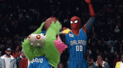 A Mascot Holding A Basketball Next To A Mascot Wearing An Orlando Jersey GIF