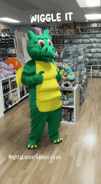 A Mascot In A Green And Yellow Dragon Costume Giving A Thumbs Up In Front Of A Sign That Says Wiggle It GIF