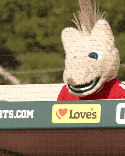 A Mascot Is Behind A Sign That Says Love 'S On It GIF