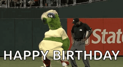 A Mascot Is Dancing On A Baseball Field While A Referee Stands Behind It . GIF