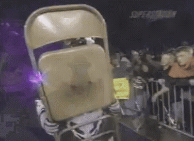 A Mascot Is Holding A Chair In Front Of His Face GIF