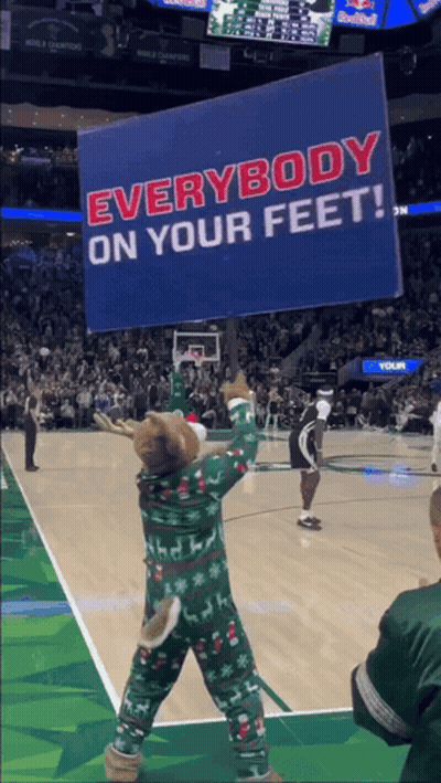 A Mascot Is Holding A Sign That Says Everybody On Your Feet GIF