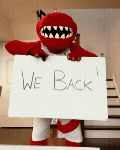 A Mascot Is Holding Up A Sign That Says We Back GIF