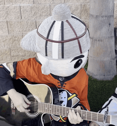 A Mascot Is Playing A Guitar And Wearing A Hockey Jersey GIF