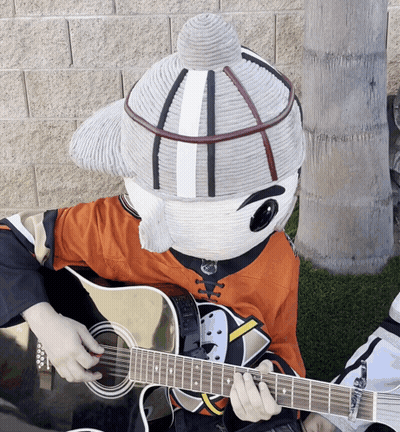 A Mascot Is Playing A Guitar And Wearing An Orange Shirt GIF