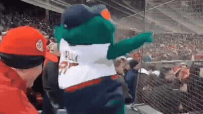 A Mascot Is Pointing At A Crowd Of People In A Stadium While Wearing A Jersey That Says Jelly . GIF