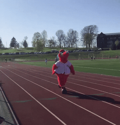 A Mascot Is Running On A Track Wearing A White Jersey GIF