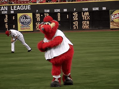 A Mascot On A Baseball Field In Front Of A Scoreboard That Says San League On It GIF