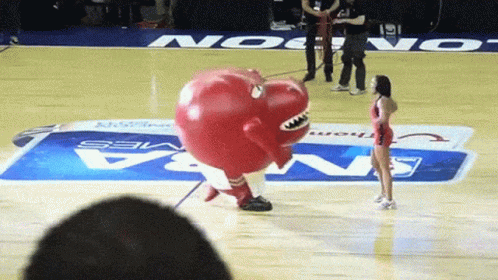 A Mascot On A Basketball Court With A Nba Logo On The Floor GIF