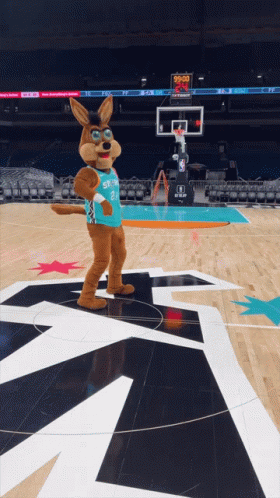 A Mascot Standing On A Basketball Court Wearing A Jersey That Says Spurs GIF