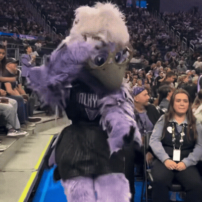 A Mascot Wearing A Jersey That Says Almy Is Dancing In Front Of A Crowd Of People GIF