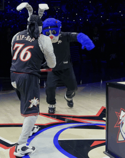 a mascot wearing a number 76 jersey stands next to another mascot