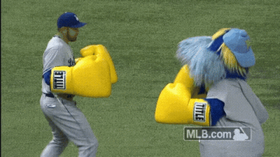A Mascot Wearing A Pair Of Yellow Boxing Gloves With The Mlb.com Logo In The Corner GIF