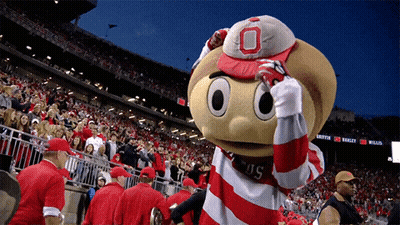 A Mascot Wearing A Red And White Striped Shirt With The Letter O On It GIF