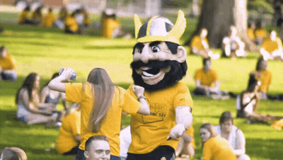 A Mascot Wearing A Yellow Shirt That Says ' Shg ' On It GIF