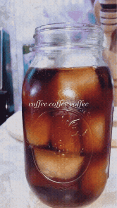 A Mason Jar Filled With Ice Cubes And The Words Coffee Coffee Coffee On It GIF
