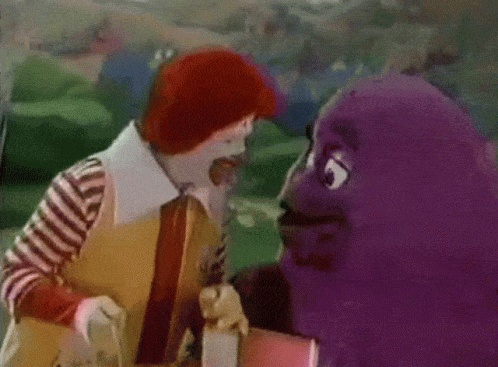A Mcdonald 'S Clown And A Mcdonald 'S Purple Character Are Standing Next To Each Other GIF