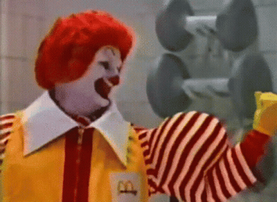 A Mcdonald 'S Clown Is Holding A Dumbbell In His Hand GIF