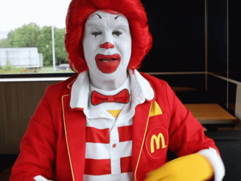 A Mcdonald 'S Clown Wearing A Red And White Striped Shirt GIF