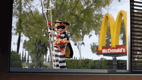 A Mcdonald 'S Sign With A Prisoner Holding A Ladder GIF