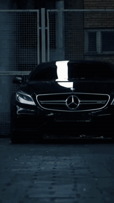 A Mercedes Car Is Driving Down A Wet Road At Night GIF