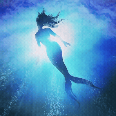 A Mermaid Is Swimming In The Ocean With The Sun Shining Through The Water GIF
