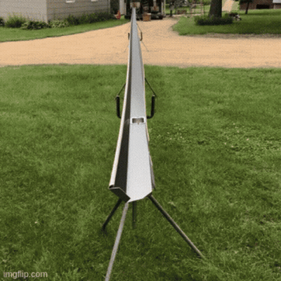 A Metal Pipe Is Sitting In The Middle Of A Grassy Field GIF