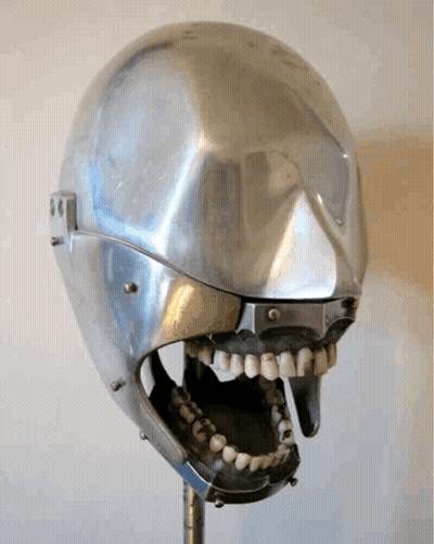 A Metal Skull With A Mouth Open And Teeth On It GIF