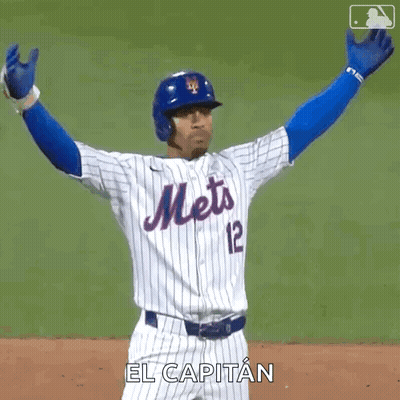 A Mets Baseball Player Is Raising His Arms In The Air . GIF