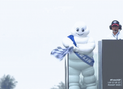 A Michelin Mascot Is Holding A Flag GIF