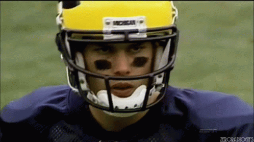 A Michigan Football Player Wearing A Yellow Helmet GIF