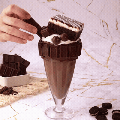 A Milkshake With A Brownie And Oreos On It GIF