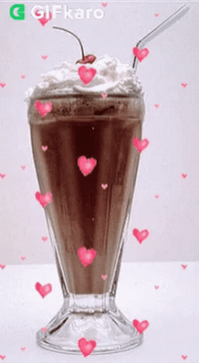 A Milkshake With Whipped Cream And A Cherry On Top Is Surrounded By Pink Hearts GIF