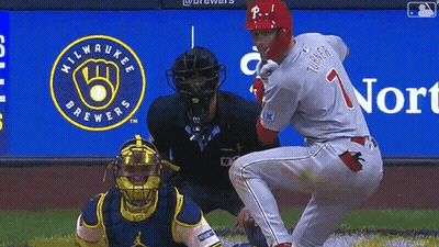 A Milwaukee Brewers Logo Is Behind The Baseball Player GIF