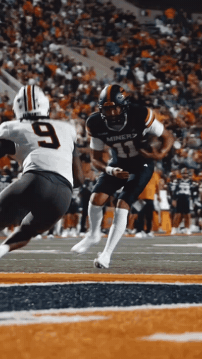 A Miners Football Player Runs With The Ball As A Player With The Number 9 Tries To Tackle Him GIF