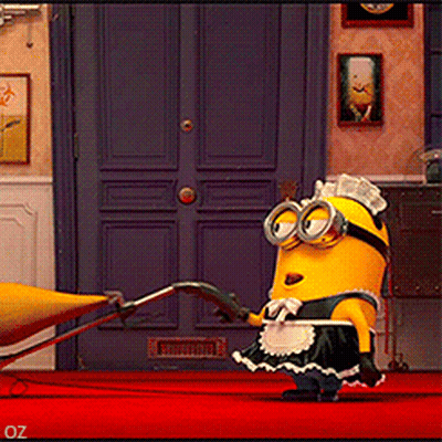 A Minion In A Maid Outfit Is Standing On A Red Carpet In Front Of A Blue Door GIF
