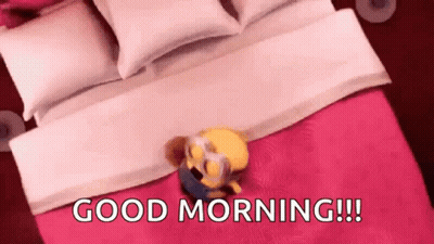 A Minion Is Laying On Top Of A Bed With The Words `` Good Morning ! '' GIF