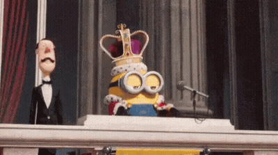 A Minion Wearing A Crown Is Sitting On A Balcony . GIF